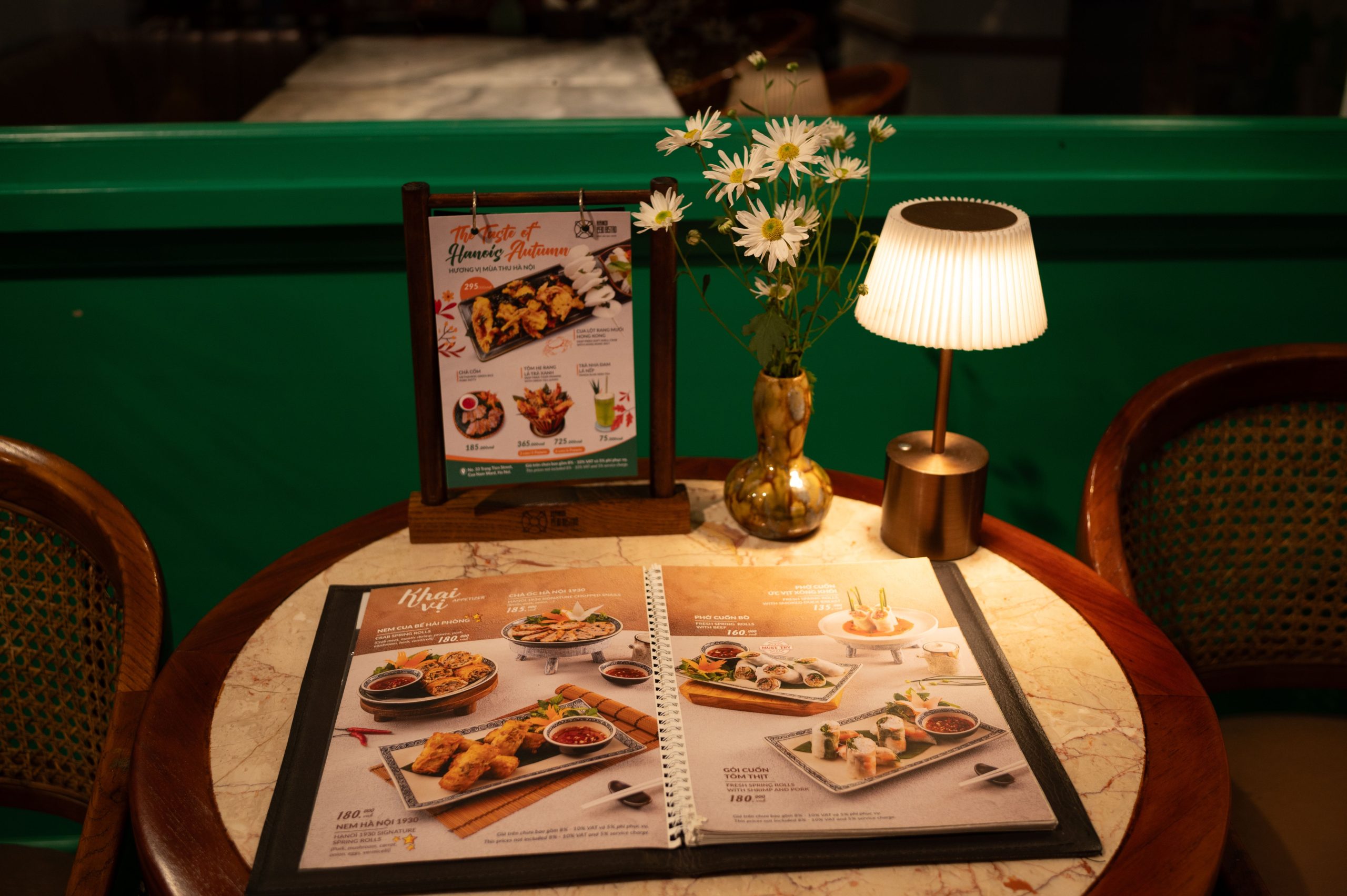 Restaurant table with a menu, flowers, and warm ambient lighting, illustrating how a welcoming palette shapes dining expectations.